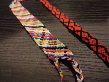 Ahşap masada renkli el yapımı bilezikler.