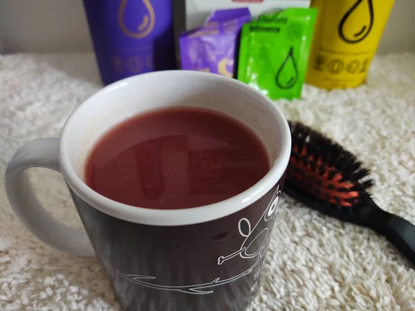 Roter Tee Tasse Und Kamm Und Kosmetik Auf Weißer Decke — Stockfoto
