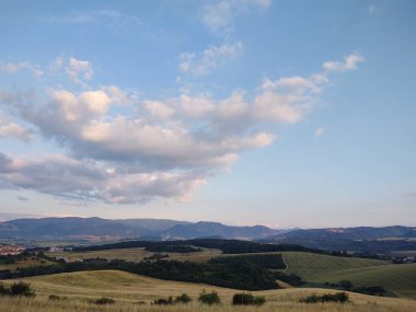 Yeşil çimlerin ve bulutlu gökyüzünün olduğu güzel bir manzara.