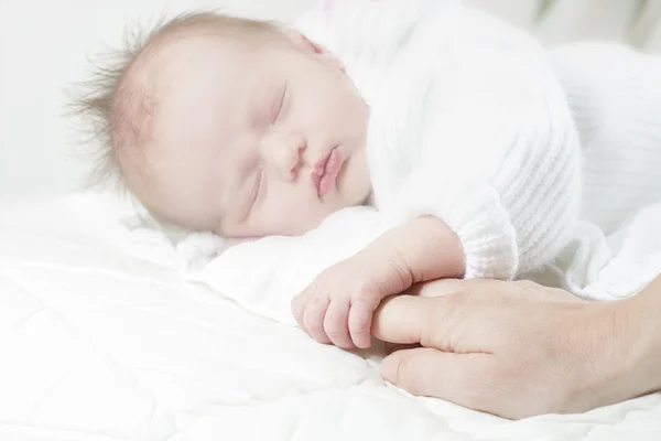 Bebé sosteniendo dedo Imagen de archivo