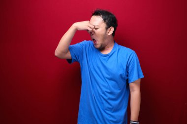 Genç Asyalı adam pis ve iğrenç bir koku alıyor.