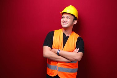 Kırmızıda izole edilmiş gülümseyen Asyalı genç adam portresi.