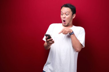 Genç Asyalı bir adam akıllı telefonu işaret ettiğinde şok olur.