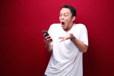 Genç Asyalı bir adam akıllı telefonu işaret ettiğinde şok olur.