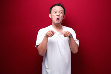 Kızgın ve stresli Asyalı genç adam kolunu kaldırıyor..