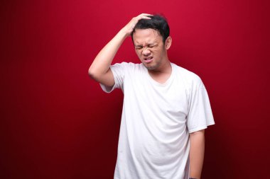 Genç Asyalı bir adamın el hareketiyle kafası karışmış ve stresli yüzü. Reklam modeli konsepti.