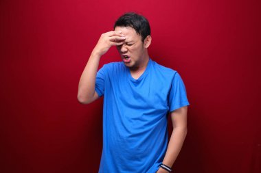 Genç Asyalı bir adamın el hareketiyle kafası karışmış ve stresli yüzü. Reklam modeli konsepti.