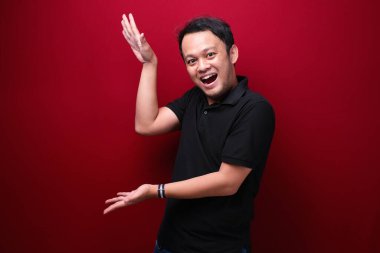 Gülümse ve mutlu Asyalı genç adam boşluğu işaret ediyor.