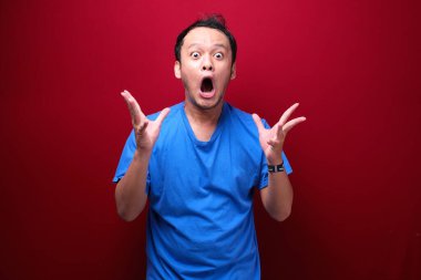 Eli açık Asyalı genç bir adamın şok olmuş yüzü. Reklam modeli konsepti.