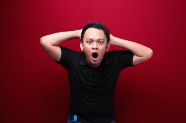 Eli açık Asyalı genç bir adamın şok olmuş yüzü. Reklam modeli konsepti.