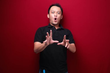 Eli açık Asyalı genç bir adamın şok olmuş yüzü. Reklam modeli konsepti.