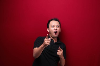 Eli açık Asyalı genç bir adamın şok olmuş yüzü. Reklam modeli konsepti.