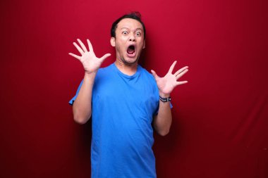 Eli açık Asyalı genç bir adamın şok olmuş yüzü. Reklam modeli konsepti.