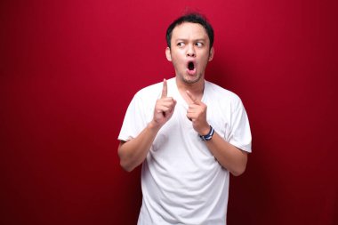 Eli açık Asyalı genç bir adamın şok olmuş yüzü. Reklam modeli konsepti.