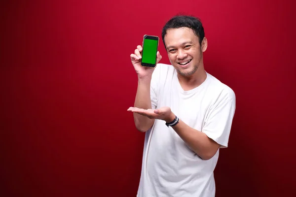 Úsměv Mladý Asiat Muž Ukazující Zelené Prázdné Místo Smartphone Červeném — Stock fotografie