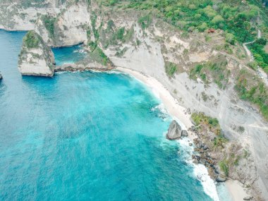 Nusa Penida, Bali, Endonezya 'daki muhteşem turkuaz mavi okyanuslu hava aracı manzaralı elmas plajı..