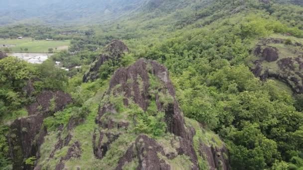 田んぼの真ん中にある岩の山の崖の空中ドローンビュー — ストック動画