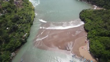 Endonezya Yogyakarta 'daki Baron plajının deniz feneri ve geleneksel tekneli görüntüsü.