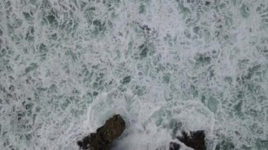 Yukarıdan aşağıya dev okyanus dalgalarının çarpışma ve köpürme görüntüsü