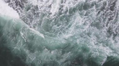 Yukarıdan aşağıya dev okyanus dalgalarının çarpışma ve köpürme görüntüsü