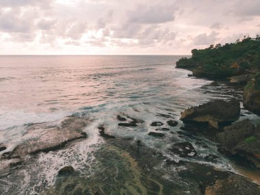 Endonezya Yogyakarta 'daki Baron plajının deniz feneri ve geleneksel tekneli görüntüsü.