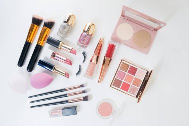 Beyaz arka planda makyaj fırçası ve dekoratif kozmetik.