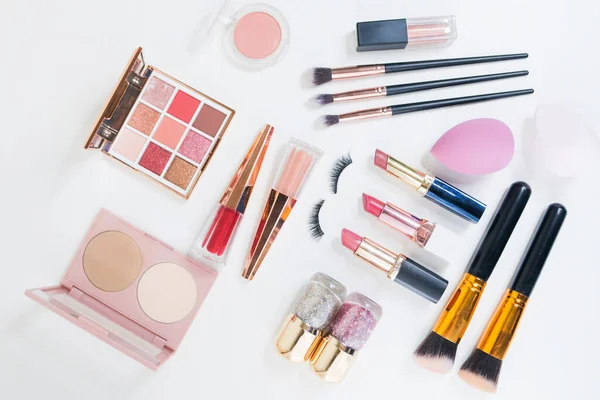 Beyaz arka planda makyaj fırçası ve dekoratif kozmetik.