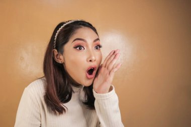 Eli açık Asyalı genç bir kadının şok olmuş yüzü. Reklam modeli konsepti.