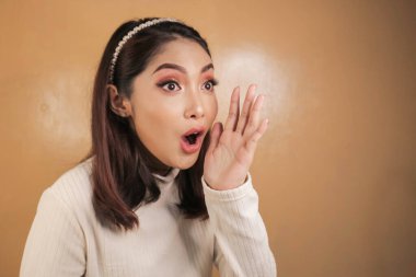 Eli açık Asyalı genç bir kadının şok olmuş yüzü. Reklam modeli konsepti.