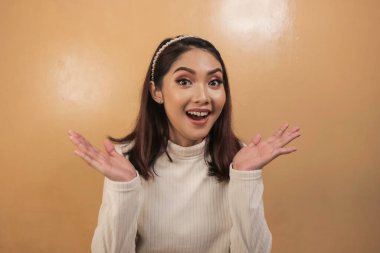 Eli açık Asyalı genç bir kadının şok olmuş yüzü. Reklam modeli konsepti.