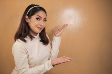 Mutlu ve gülümseyen yüz, boş alanda el işaretli genç Asyalı kızın gülüşü..