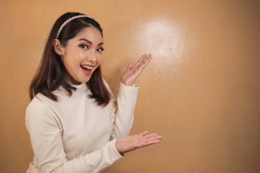 Mutlu ve gülümseyen yüz, boş alanda el işaretli genç Asyalı kızın gülüşü..