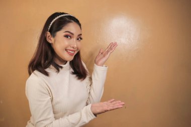 Mutlu ve gülümseyen yüz, boş alanda el işaretli genç Asyalı kızın gülüşü..