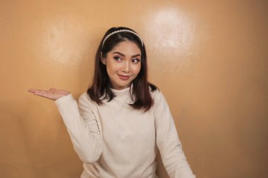 Mutlu ve gülümseyen yüz, boş alanda el işaretli genç Asyalı kızın gülüşü..