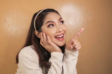 Mutlu ve gülümseyen yüz, boş alanda el işaretli genç Asyalı kızın gülüşü..