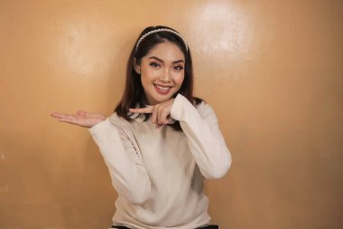 Mutlu ve gülümseyen yüz, boş alanda el işaretli genç Asyalı kızın gülüşü..