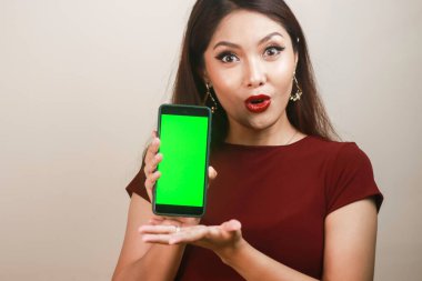 Asyalı güzel kız kırmızı gömlekli akıllı telefondan şok oluyor.
