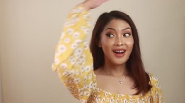 Mutlu ve gülümseyen yüz, boş alanda el işaretli genç Asyalı kızın gülüşü..