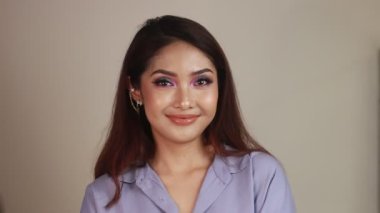 Genç Asyalı kadın gülümseyen yüzüyle selfie çekiyor.