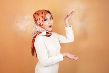 Genç Müslüman Asyalı kadının, kopyalama alanını gösteren şok suratı