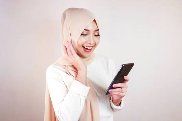 Retrato Alegre Joven Musulmana Asiática Sonriendo Mientras Mira Teléfono Celular — Foto de Stock