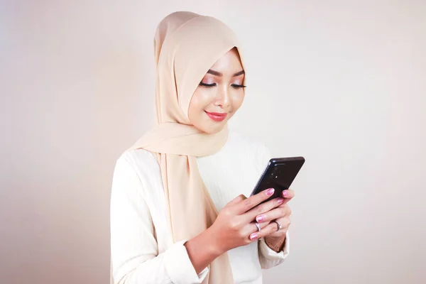 Cep Telefonuna Bakarken Gülümseyen Neşeli Genç Müslüman Asyalı Kadının Portresi — Stok fotoğraf