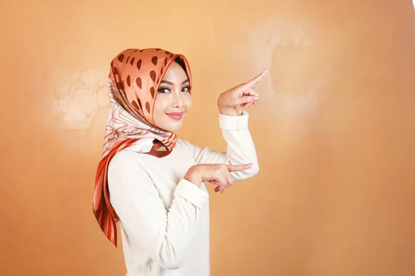 朗らかな若いイスラム教徒のアジアの女性は笑顔でスペースをコピーする側を指して — ストック写真