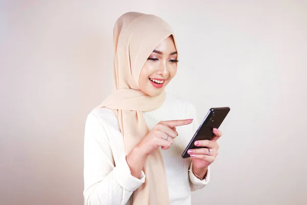 Retrato Alegre Joven Musulmana Asiática Sonriendo Mientras Mira Teléfono Celular —  Fotos de Stock