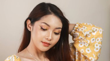 Makyajlı gülümseyen genç Asyalı kadın beyaz arka planda. Güzellik konsepti.