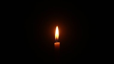 Mum ışığı siyah arkaplanda parlak bir şekilde yanıyor..