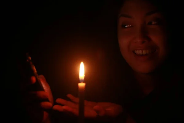 在漆黑的夜晚 亚洲女人拿着蜡烛对着手机笑 — 图库照片