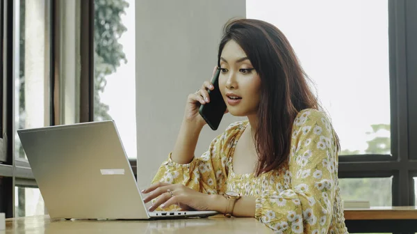 Jovem Mulher Asiática Trabalhando Computador Portátil Enquanto Fala Telefone Café — Fotografia de Stock