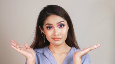 Leylak gömlekli güzel bir Asyalı kızın kafa karıştırıcı hareketi..