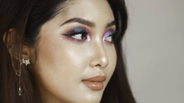 Renkli makyajlı güzel bir kızın yakın plan portresi.